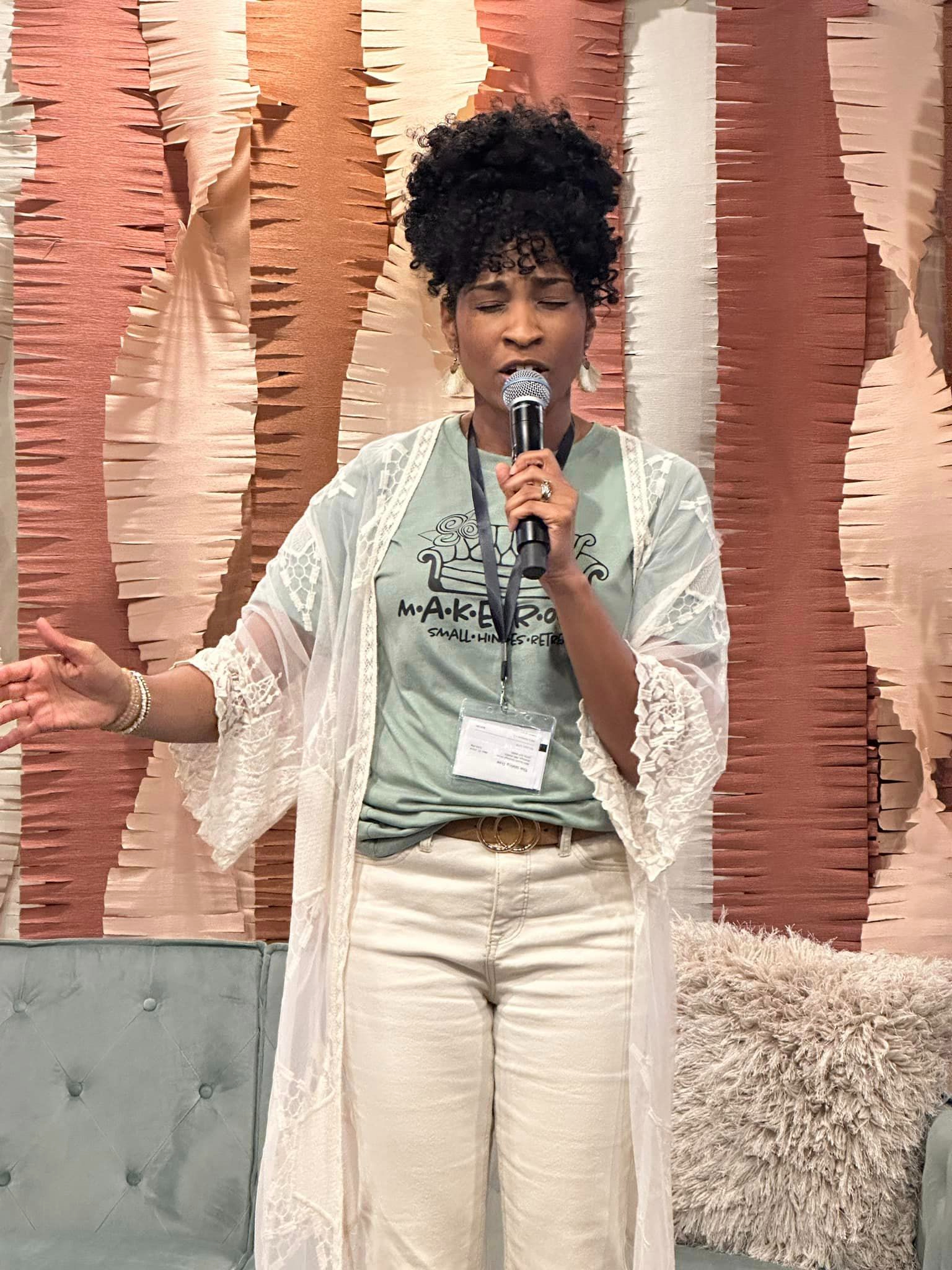 Rose Edwards praying onstage at Small Hinges Retreat